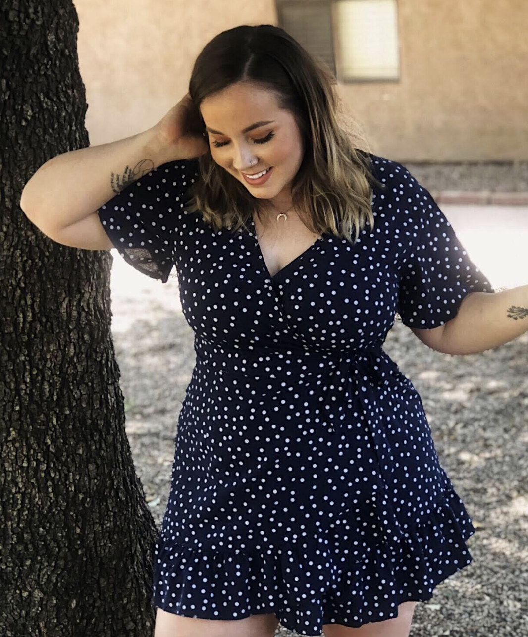 reviewer wearing navy and white dotted dress