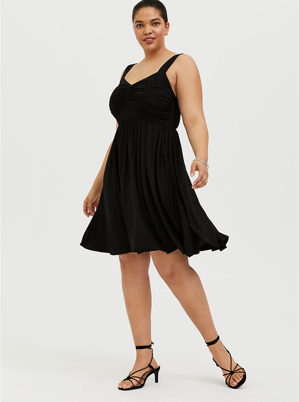 model in black knee-length dress with thick tank-top sleeves