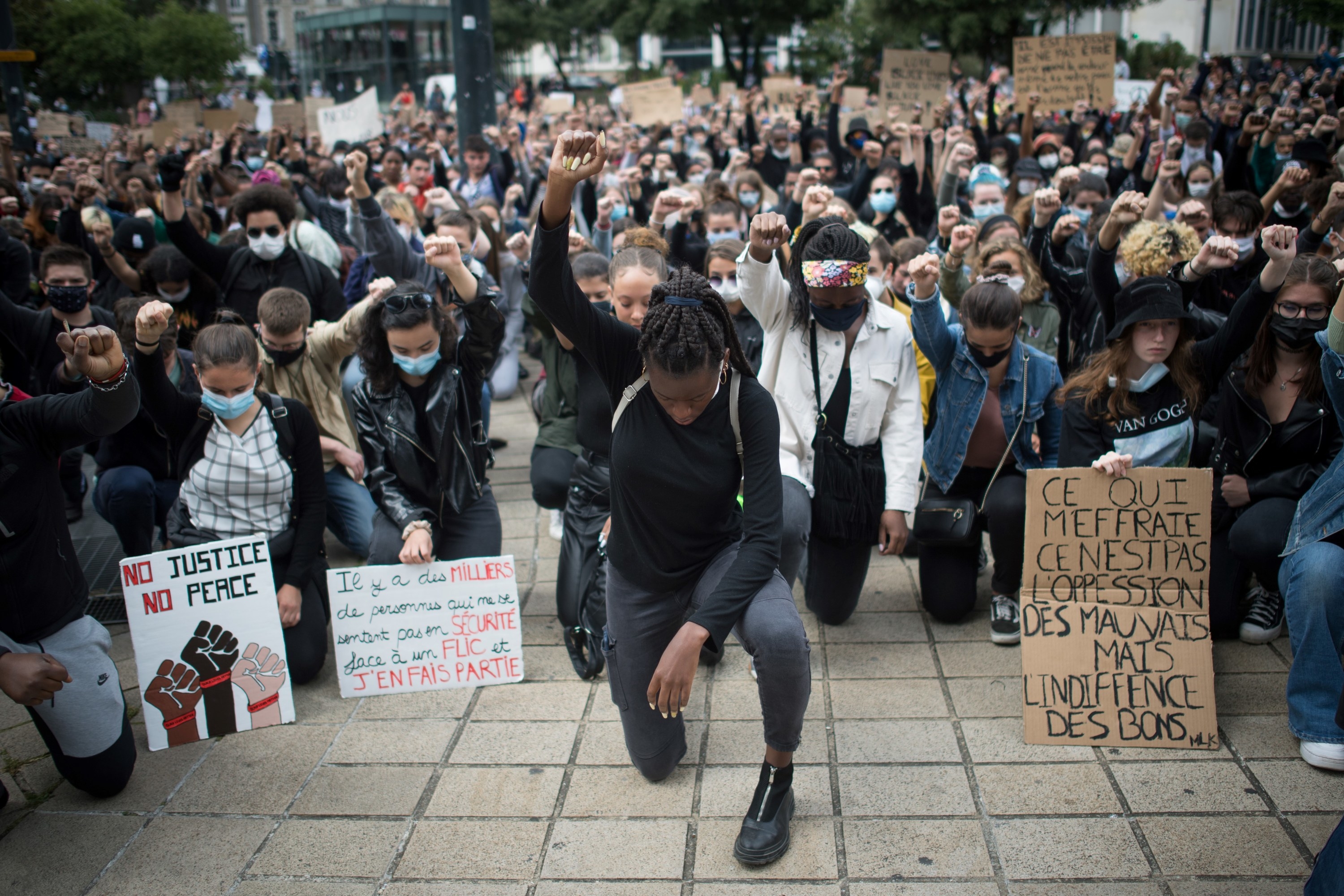 Protestors take a knee and raise their fists at a Black Lives Matter march