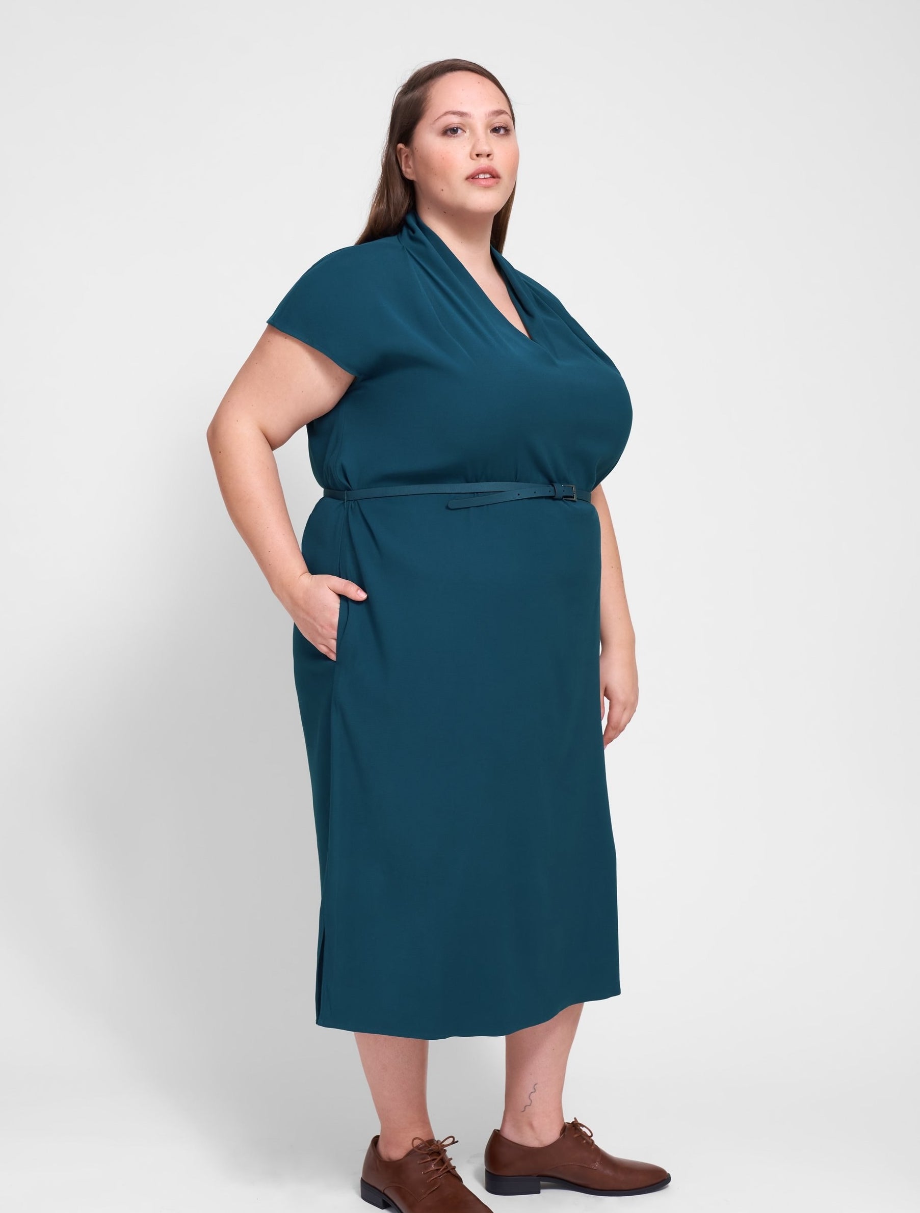 model in teal dress with short sleeves, V-neck, and high ruched collar