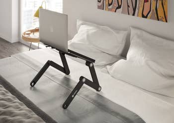 laptop stand on bed