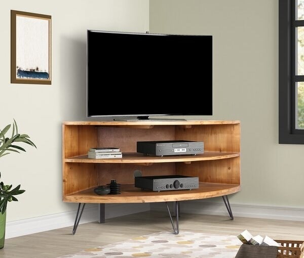 A two shelf console with hairpin legs placed snug into a corner of a room. It has a TV on the table top. 