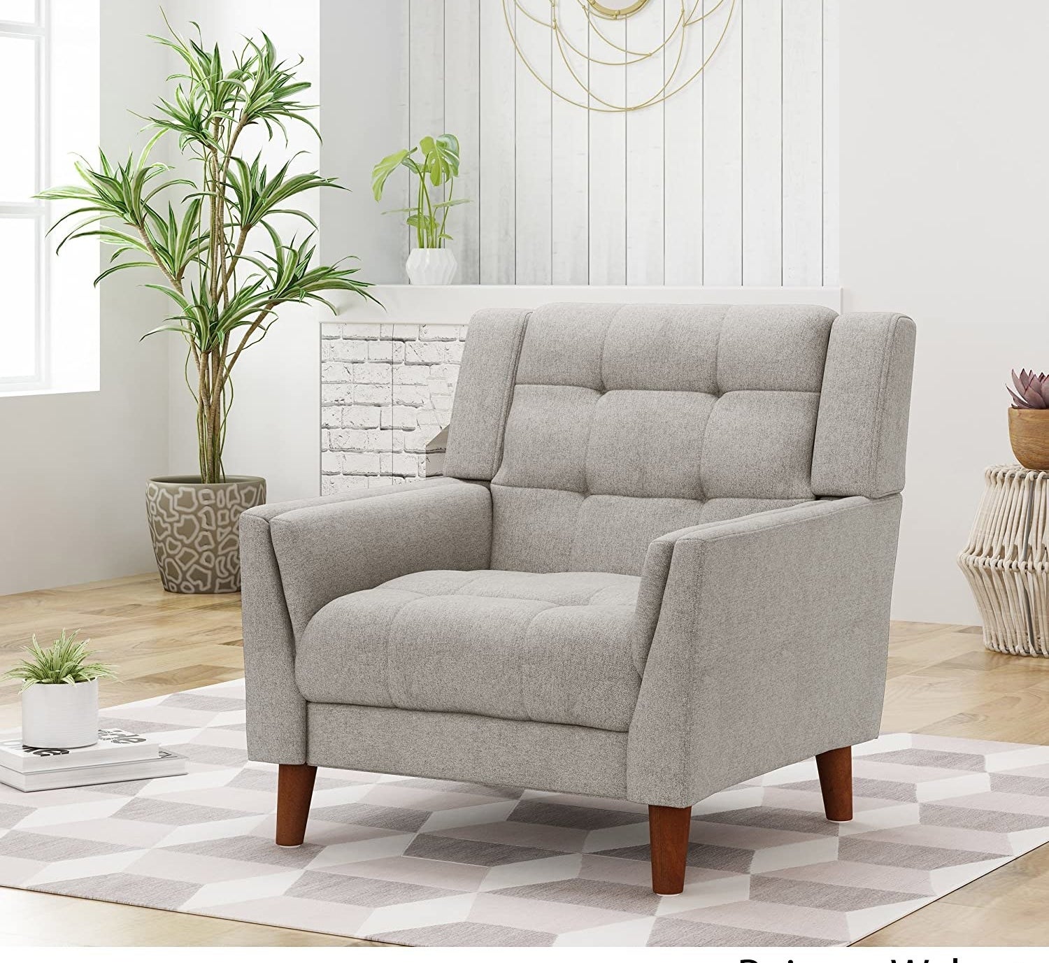 The grey tufted fabric armchair with wooden legs