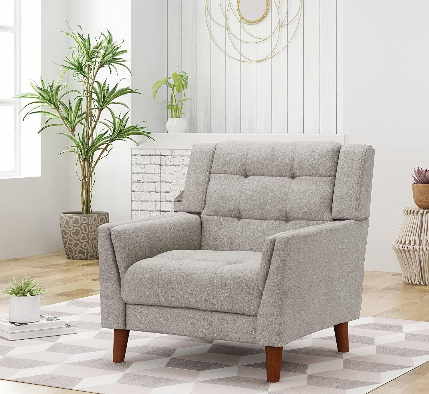 The grey tufted fabric armchair with wooden legs