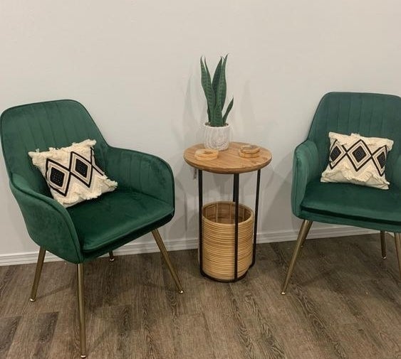Reviewer&#x27;s photo of two of the green velvet arm chairs with subtle pleating