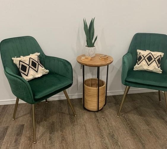 Reviewer's photo of two of the green velvet arm chairs with subtle pleating
