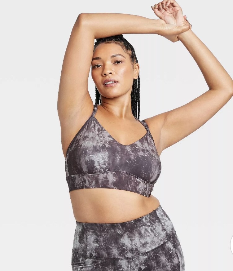 a model wearing a marbled grey and light grey sports bra with thin straps
