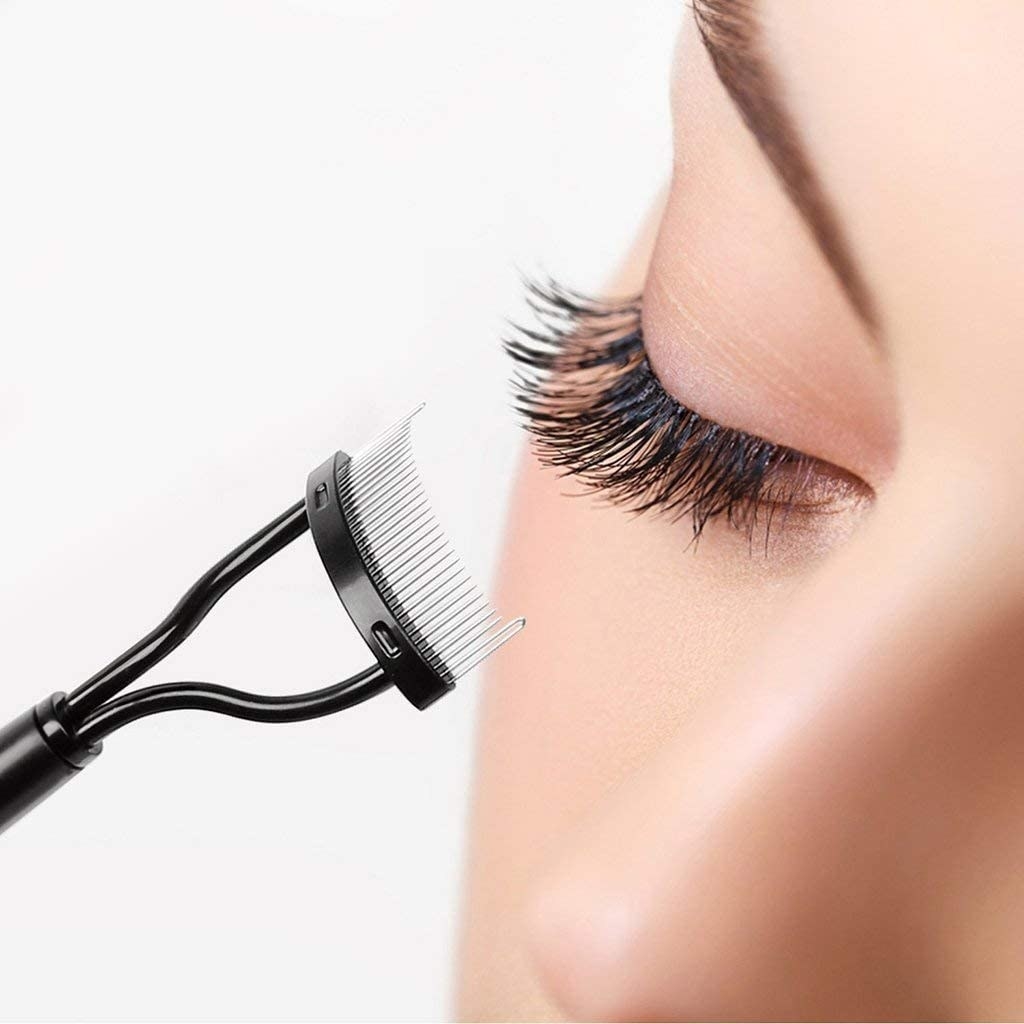 A close up of a person using the brush to comb out their eyelashes