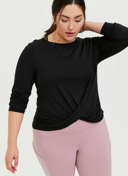 Model wears black Torrid twist-front active top with pink leggings