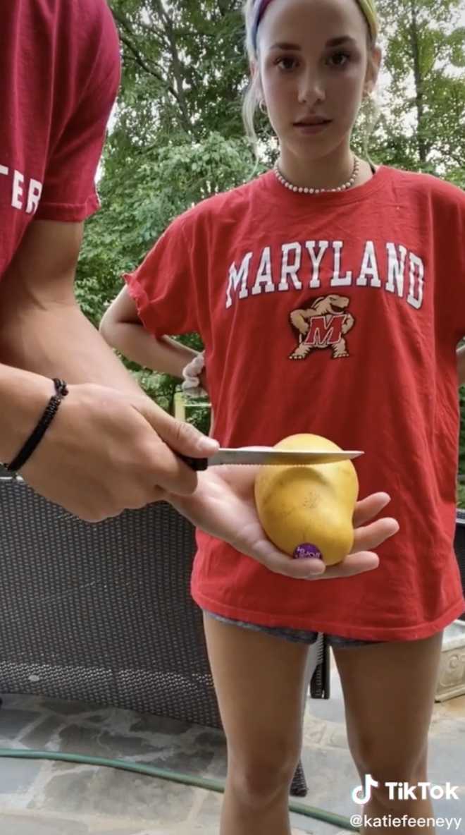 Sean using a knife to slice the mango in half.