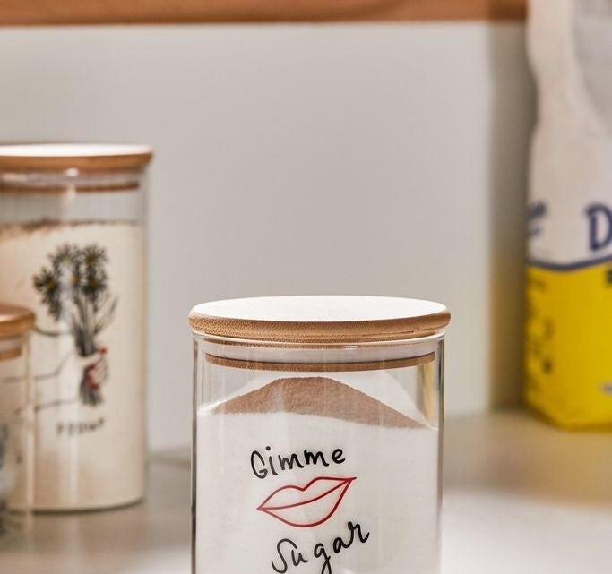 Clear glass jar with a wood lid and an illustration of lips in red and the words &quot;Gimme Sugar&quot; in black above and below it