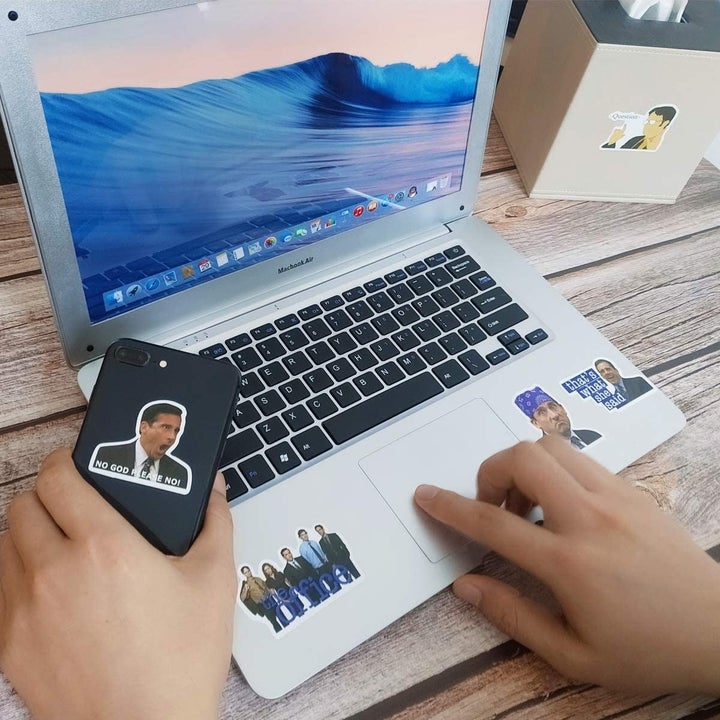 A computer and phone covered in the stickers