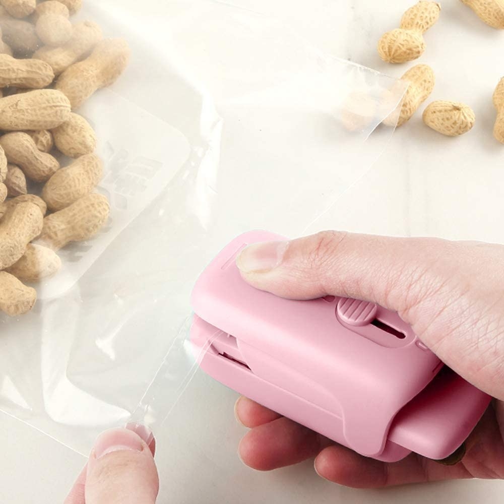 A person using the bag sealer to reseal a bag of peanuts