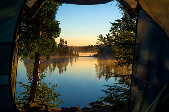 望通过门口的一个帐篷在晨雾和新月形湖,优越的国家森林,明尼苏达州