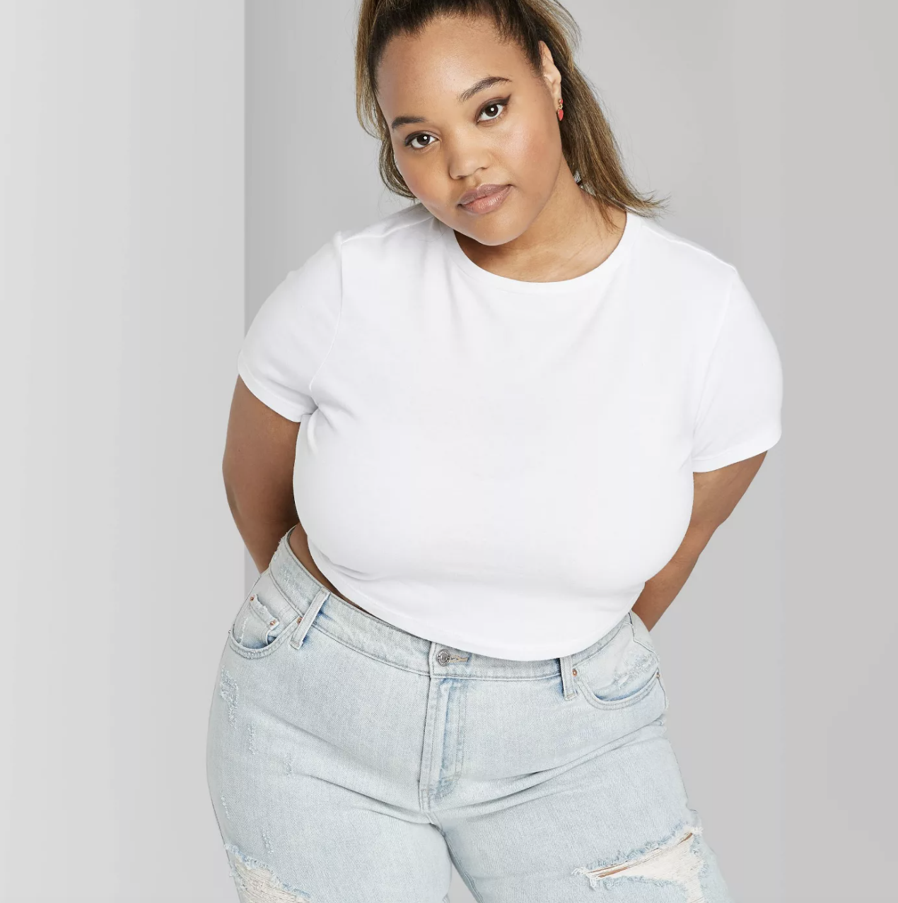 a model wearing a cropped white tee