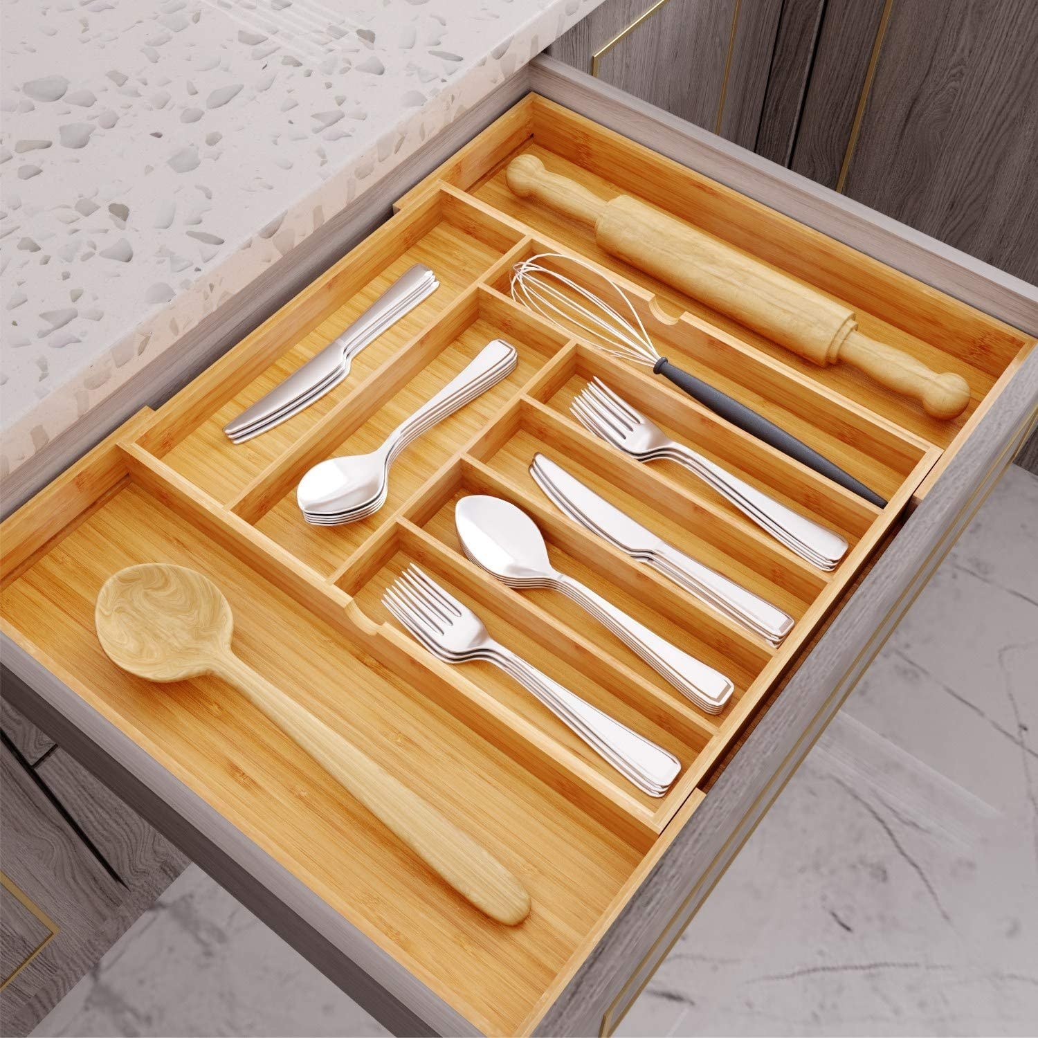 An open kitchen drawer with the bamboo organizer perfectly inside. It has 10 different sized compartments for utensils.