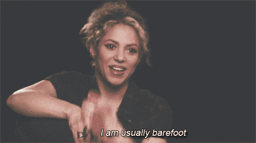 A gif of Shakira holding up her foot and saying &quot;I&#x27;m usually barefoot&quot;
