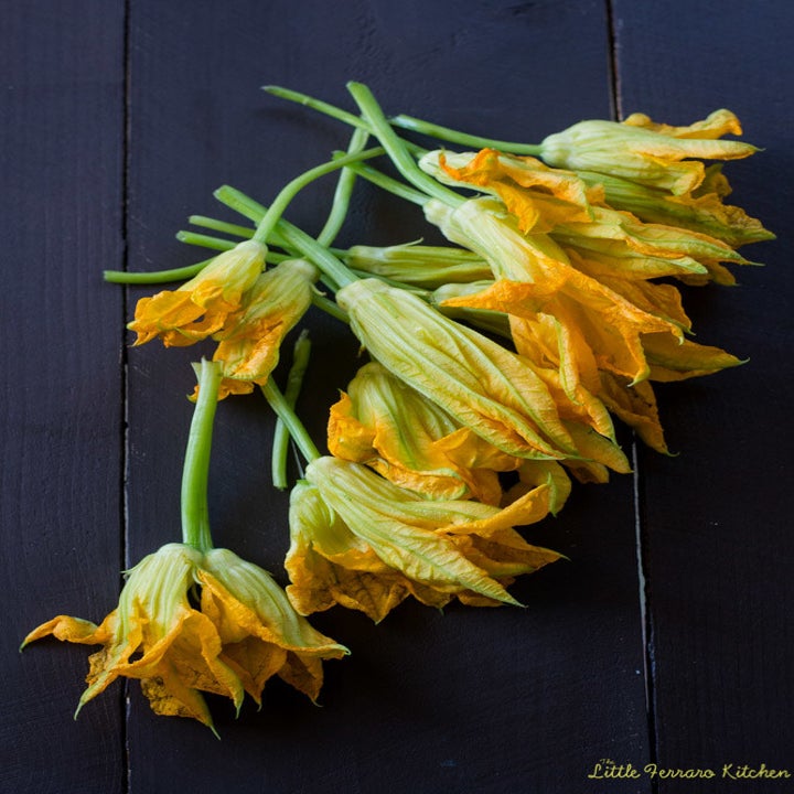Squash blossoms resting on a tabletop.