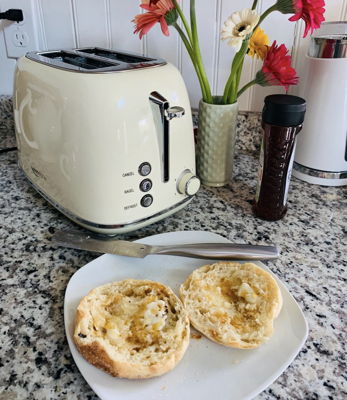 Reviewer image of a white/cream-colored toaster next to a freshly toasted English muffin