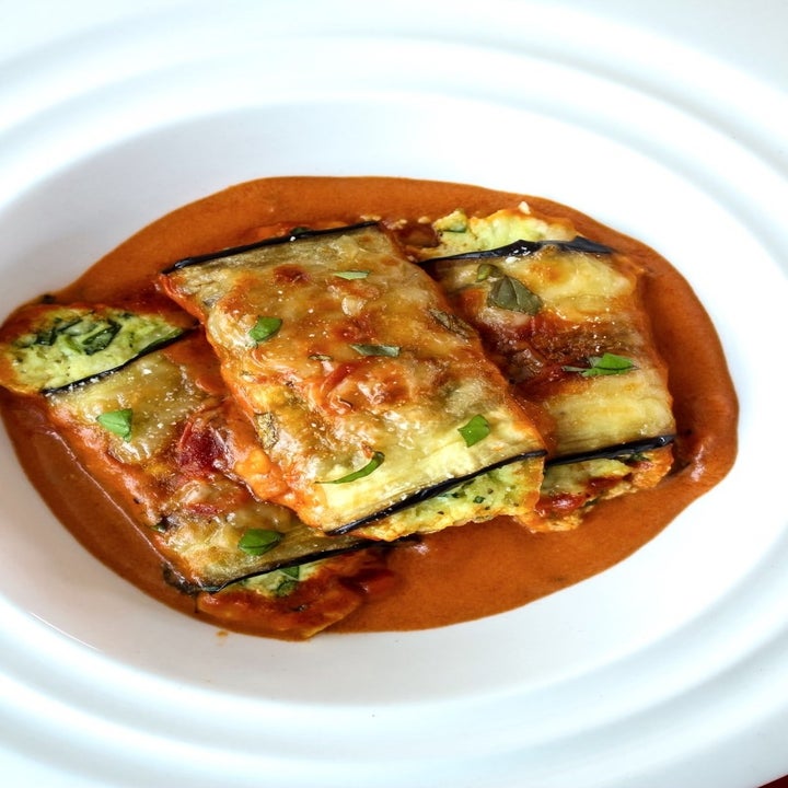 3 plated eggplant rollatini in tomato sauce.