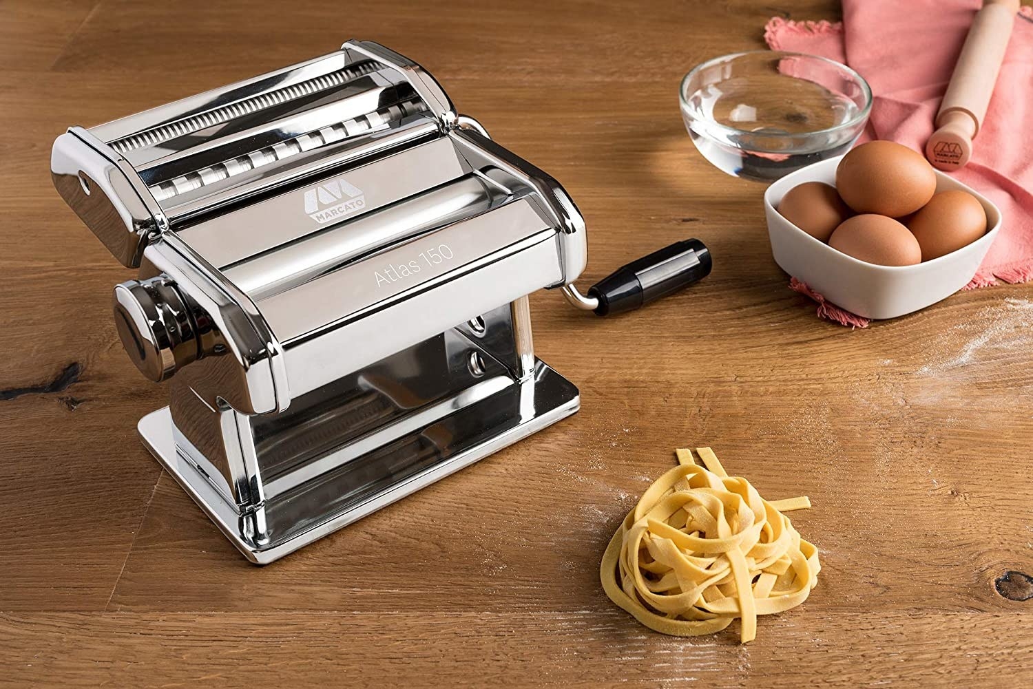 The pasta machine next to a small pile of fresh pasta
