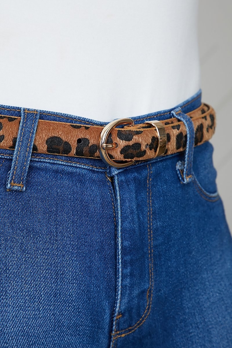 The fuzzy textured belt with gold buckle on a pair of jeans
