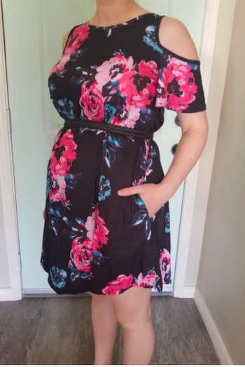 A reviewer wearing the dress in navy floral with a belt