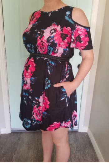 A reviewer wearing the dress in navy floral with a belt
