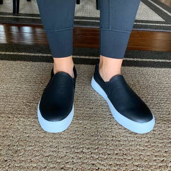Reviewer wearing the slip-on sneaker in black with a white wide sole