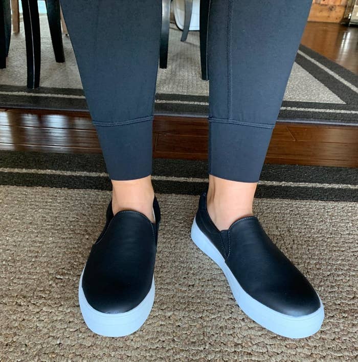 Reviewer wearing the slip-on sneaker in black with a white wide sole