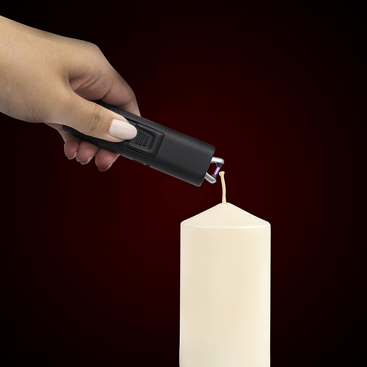 A person using the electric lighter to light a candle
