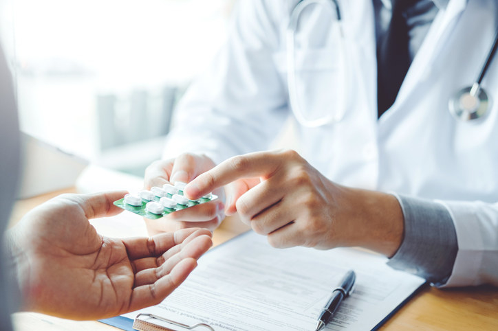 Photo of person pointing to medication.