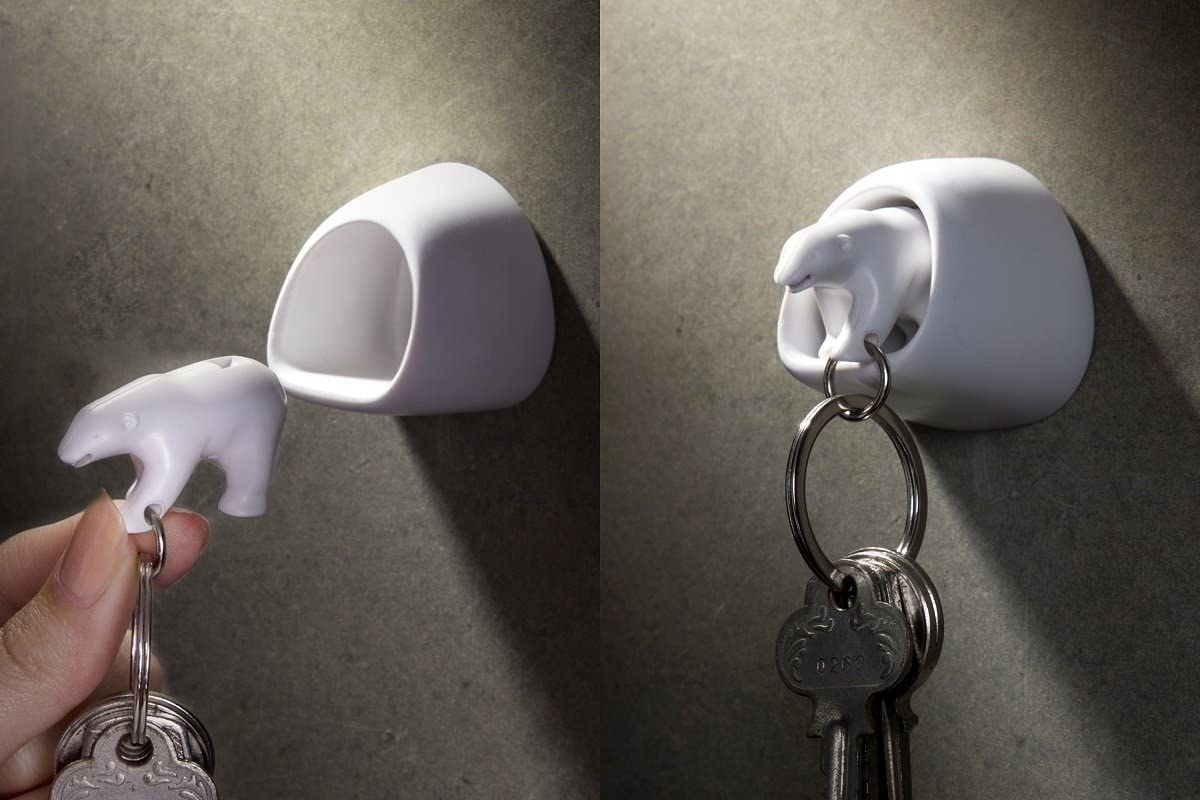 A double photo of a person putting the polar bear key chain into the wall mounted book