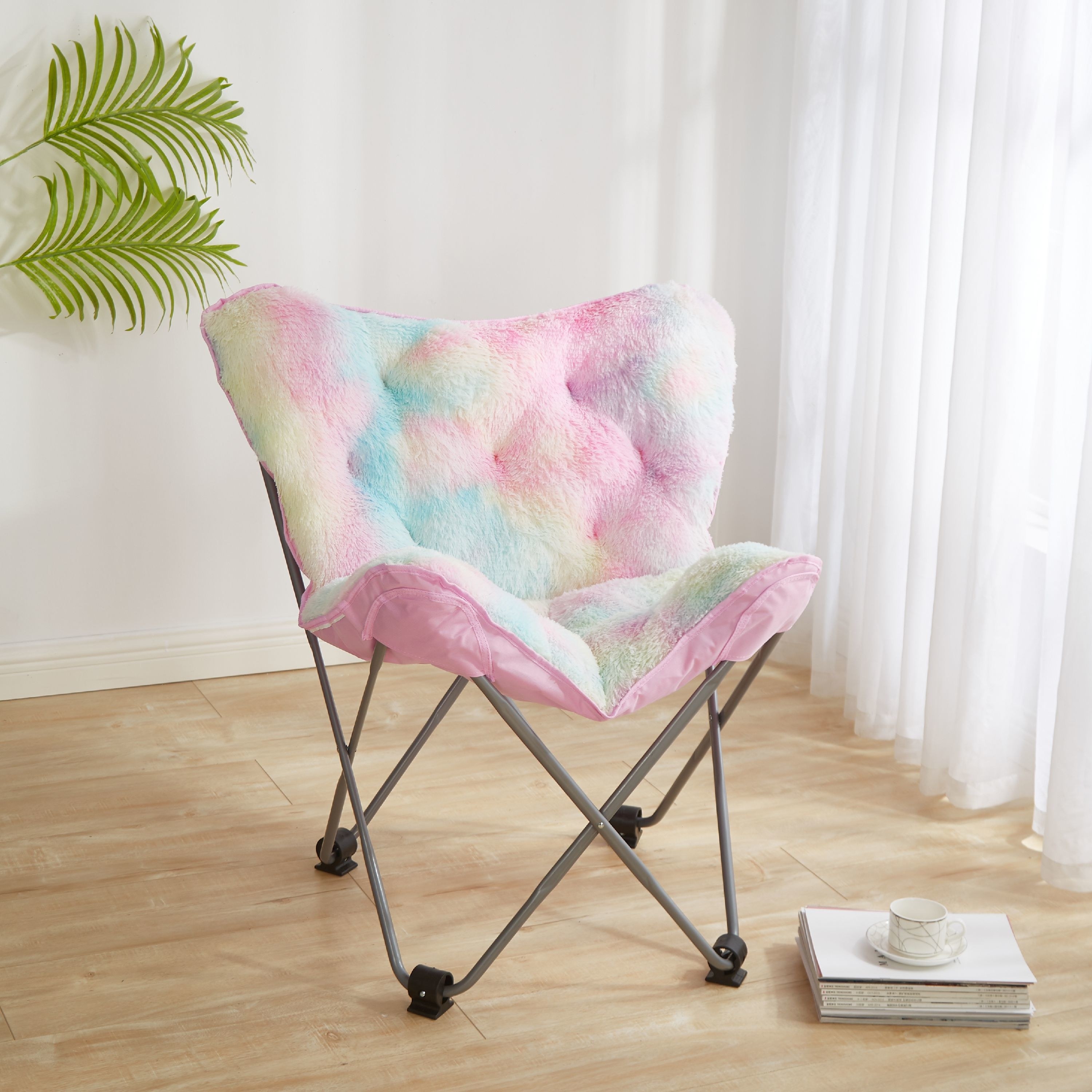 A folding chair with thin metal legs and rubber stopper with a light-colored rainbow cushion