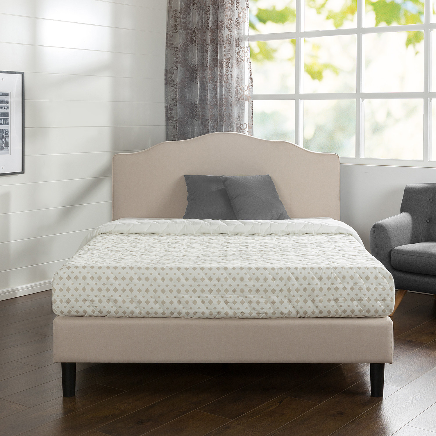 A cream-colored bed frame with headboard and brown wooden legs