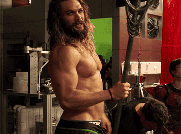 Jason Momoa shirtless with a staff used for his Aquaman character
