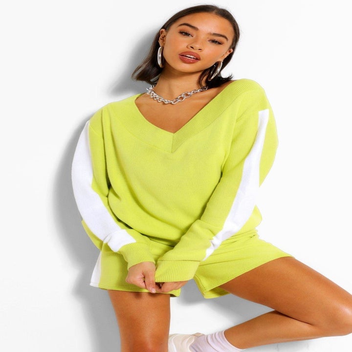 Model in a sweatshirt lounge set with v-neck top and shorts, in lime green with white stripe down the sides, available in women's sizes