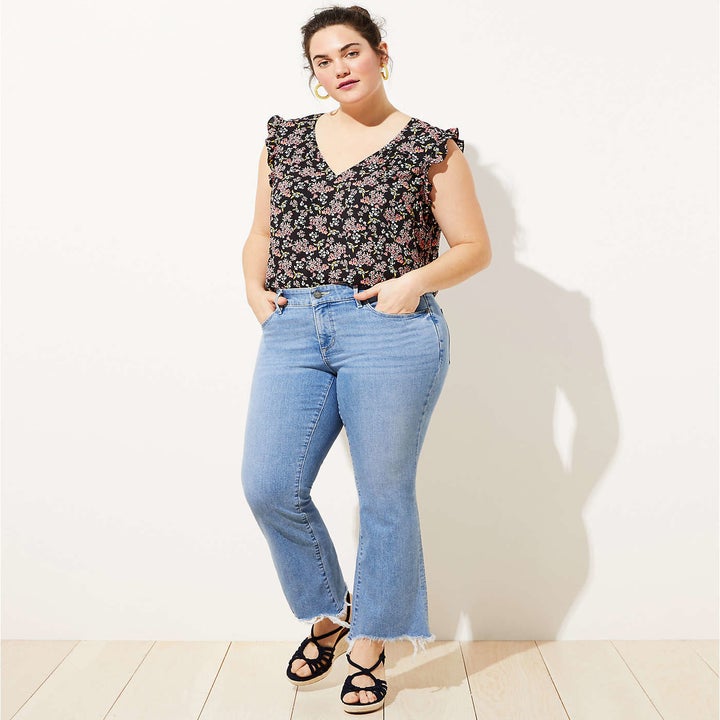Model in a pair of light-wash flare jeans, available in women's sizes