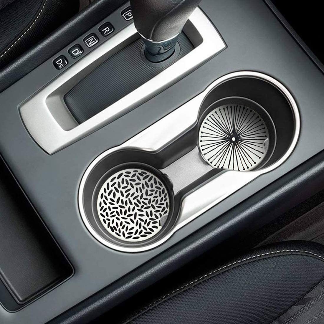 Two patterned coasters inside of a car cupholder