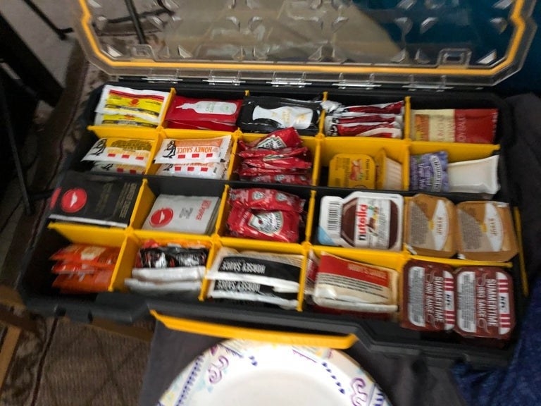A tackle box filled with extra sauce packets 