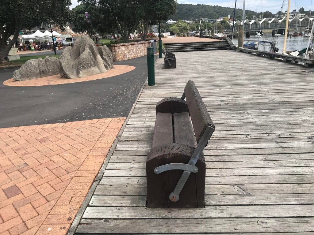 A wood bench with a back that flips from one side to the other