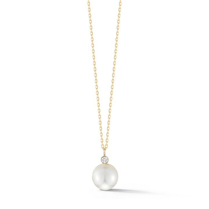 Gold chain necklace with a pendant that's a diamond sitting on top of a pearl