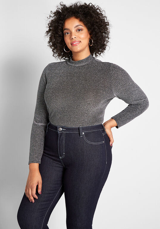 A model wearing the silver long-sleeved top tucked into jeans