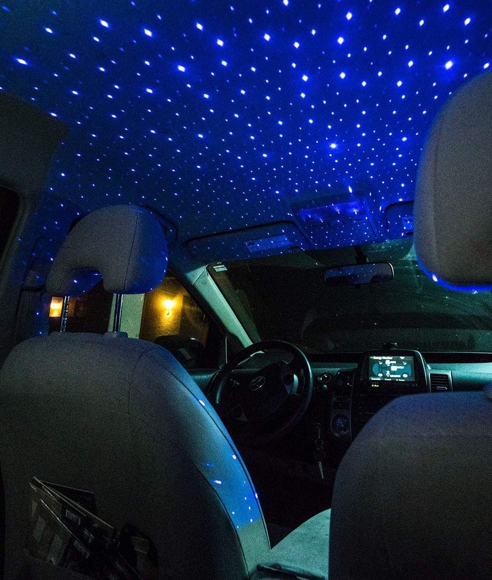 The ceiling of a car covered in little light projections that look like stars