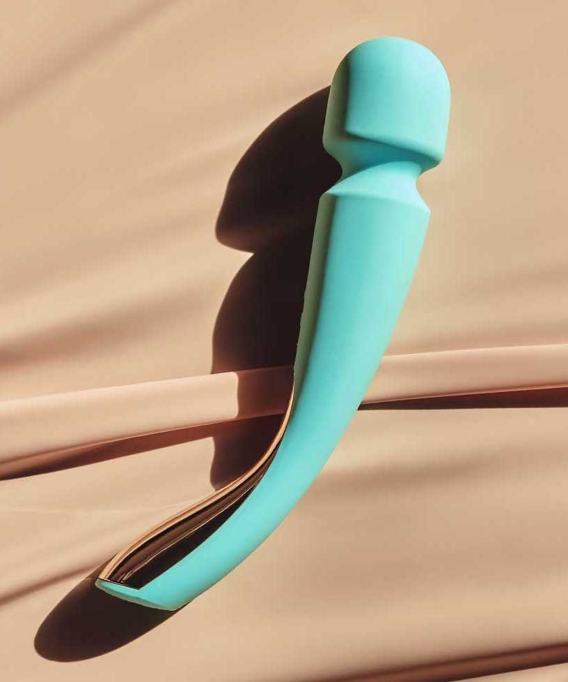 a curved massager with a rounded tip on one end and a golden handle