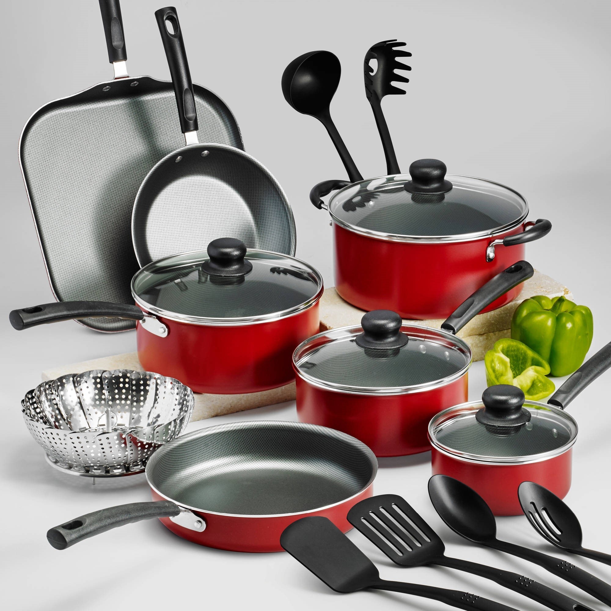 red cookware set including pots, pans, and utensils 