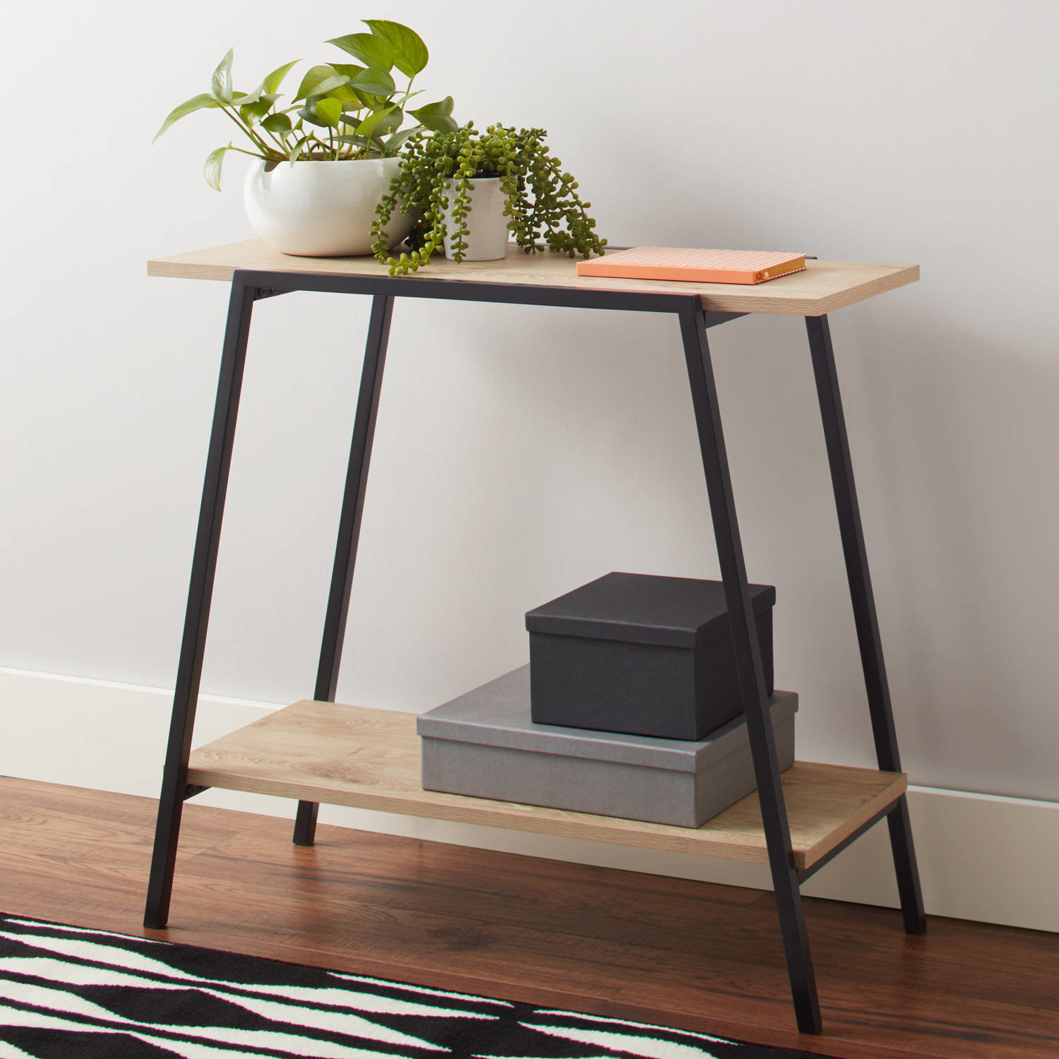 two level console table with light wood and black legs 