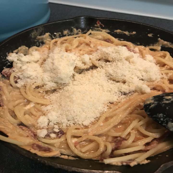 grated cheese on top of spicy miso pasta in a pan