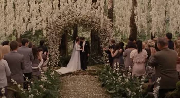 Bella and Edward beneath a floral arch