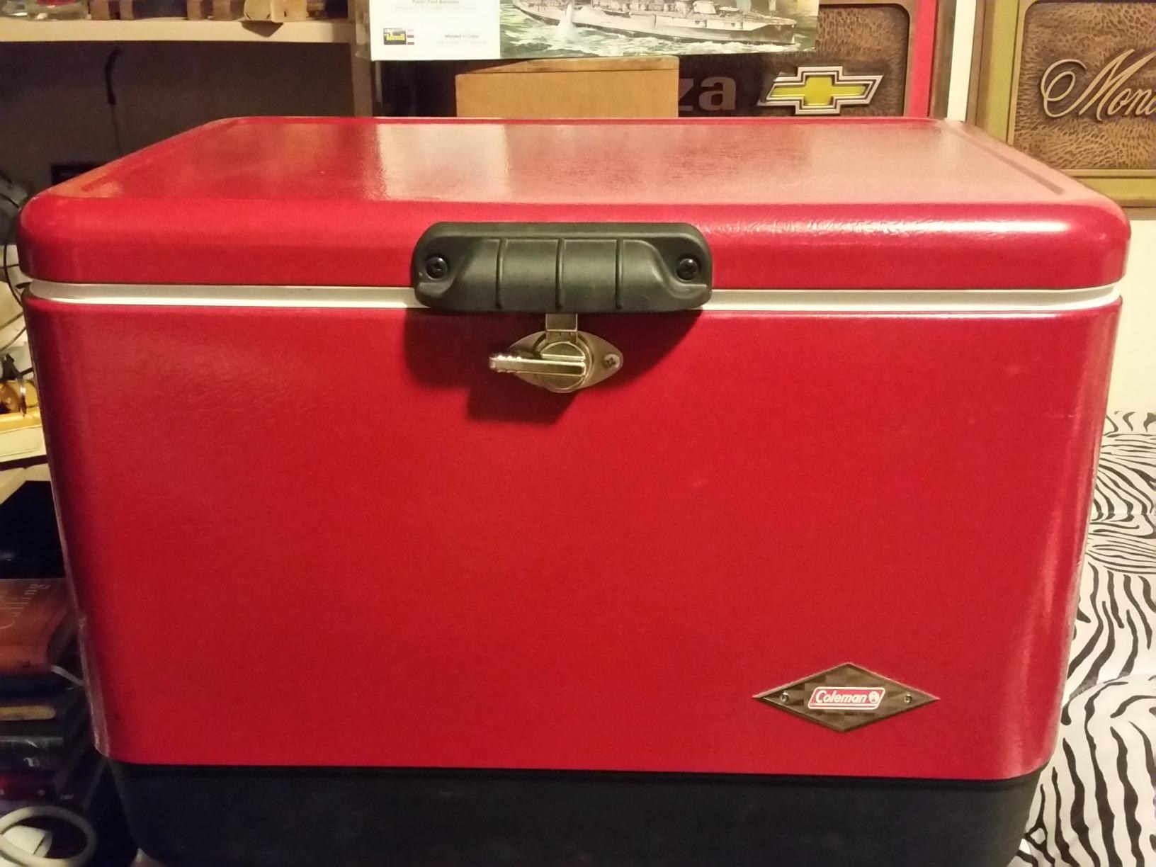 red cooler with metal latch and small Coleman logo on front